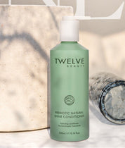 Two bottles of Twelve Beauty shampoo and conditioner on a textured surface with 'NEW' branding in the background.